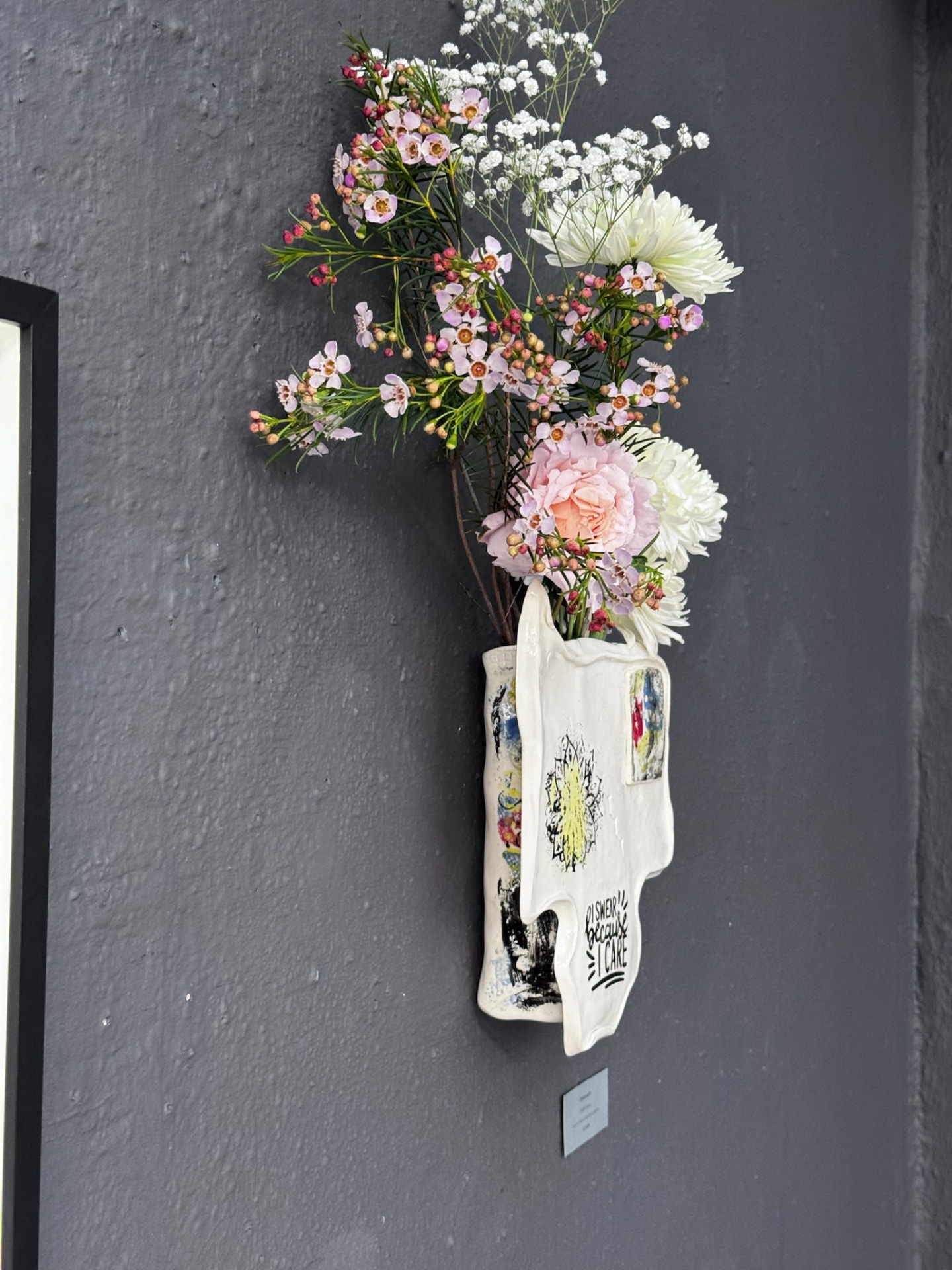 Side view of the exhibited wall vase on the gallery wall